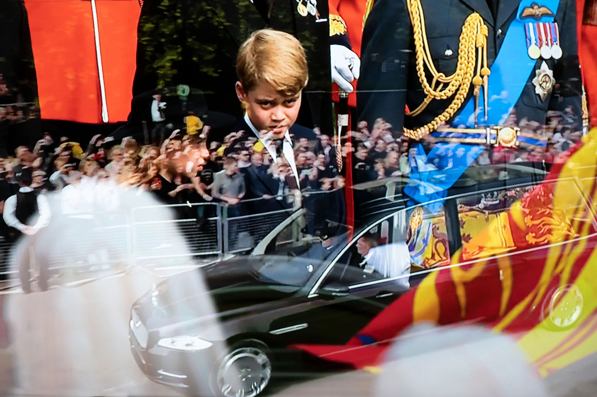 عکس انعکاس تصویر شاهزاده جورج بر روی تصویر خودرو حمل تابوت ملکه الیزابت