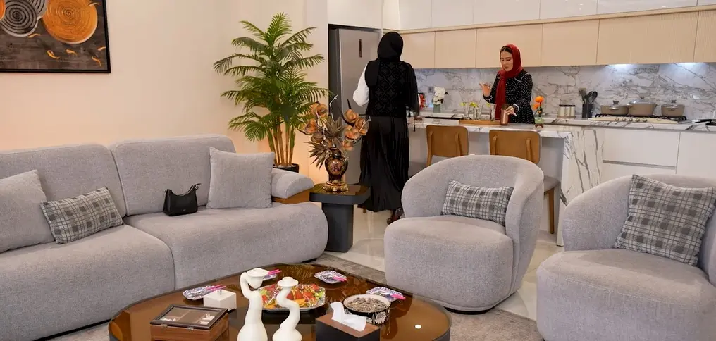 نگاهی به چیدمان منزل شیدا یوسفی در ضیافت شام ایرانی به سبک مینیمال لوکس/آشپزخانه‌ی مدرن با متریال لوکس، مبلمان مینیمال با فرم‌های نرم، لوستر مدرن، کاکتوس و کاج مطبق