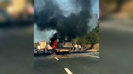 ببینید / اولین تصاویر از آتش گرفتن یک خودروی سواری روی ماشین یدک‌کش بعد از تصادف با کامیون وسط اتوبان