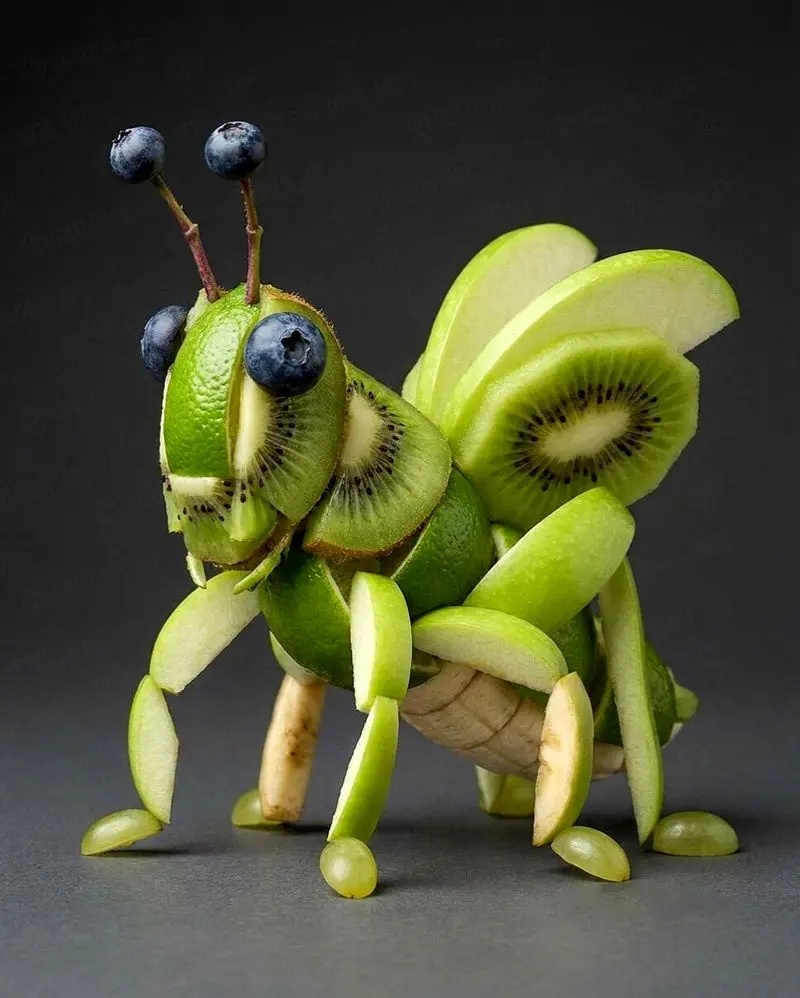 تصویری از مجسمه‌های خلاقانه ساخته‌شده با میوه، شامل حیواناتی مانند سگ سیبی، گربه هندوانه‌ای و حلزون میوه‌ای که با برش‌های دقیق و ترکیب رنگ‌های طبیعی میوه‌ها طراحی شده‌اند؛ مناسب برای معرفی هنر میوه‌آرایی و ترندهای خلاقانه در شبکه‌های اجتماعی.