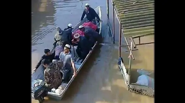 عکس / پیکر مادر 2 شهید آق قلا با قایق تشییع شد/ خانه او در محاصره سیل بود