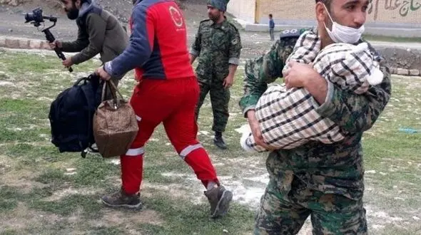 سقوط وحشتناک بچه ای سیل زده از بالگرد در لرستان ! / مامور پلیس او را روی هوا گرفت! + عکس بعد حادثه