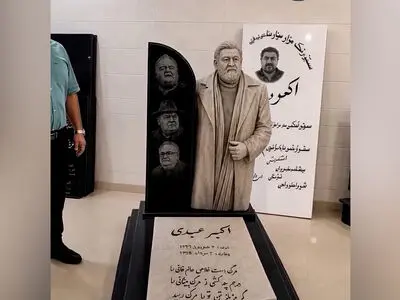 فیلم / سنگ قبر اکبر عبدی با مجسمه بازیگر ماندگار و شعر نوشته ای از مرگ / روحش شاد