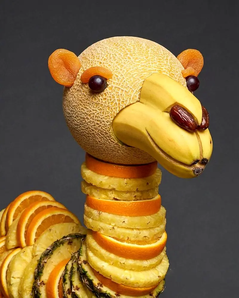 تصویری از مجسمه‌های خلاقانه ساخته‌شده با میوه، شامل حیواناتی مانند سگ سیبی، گربه هندوانه‌ای و حلزون میوه‌ای که با برش‌های دقیق و ترکیب رنگ‌های طبیعی میوه‌ها طراحی شده‌اند؛ مناسب برای معرفی هنر میوه‌آرایی و ترندهای خلاقانه در شبکه‌های اجتماعی.