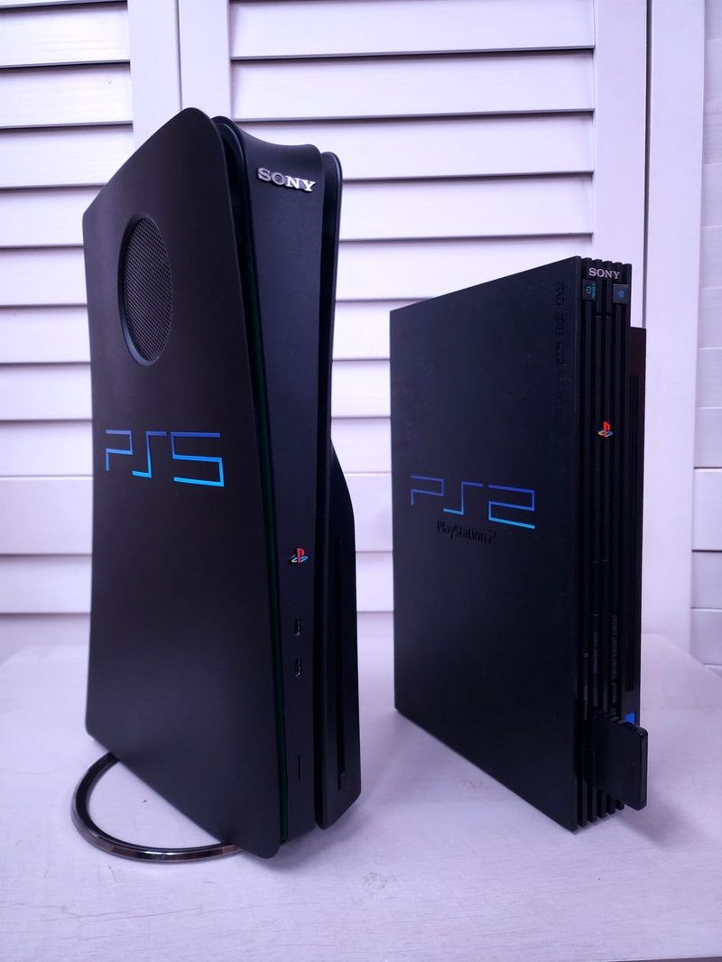 کنسول پلی‌استیشن ۲ در کنار پلی‌استیشن ۵ روی میز با ظاهر PS2