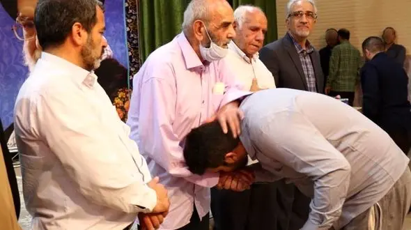 بوسه زندانیان آزاد شده زندان قم بر دستان پدران شهدا