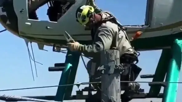 ببینید/ انتقال عجیب تکنسین برق از روی کابل‌های فشار قوی با هلیکوپتر + فیلم