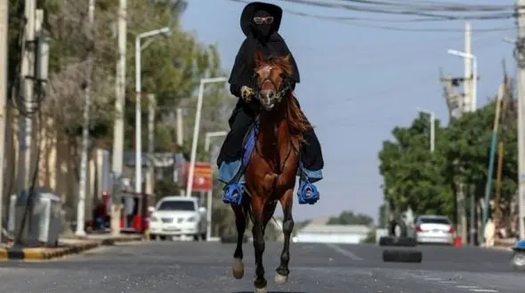 ببینید / اسب سواری یک زن با حجاب کامل در خیابان حاشیه ساز شد + فیلم