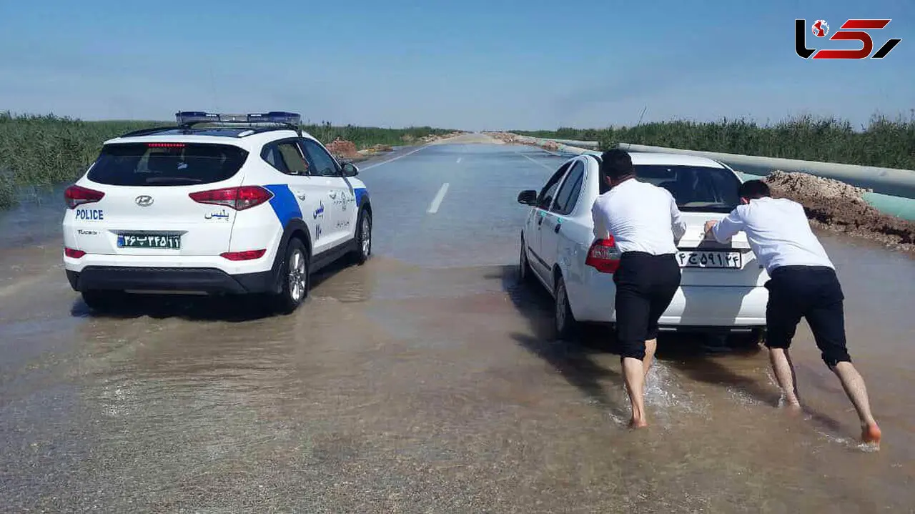 صحنه ای زیبا از امدادرسانی پلیس راهور آبادان / 2 مامور  پلیس پاچه‌های شلوارشان را در سیل بالا زدند ! +عکس