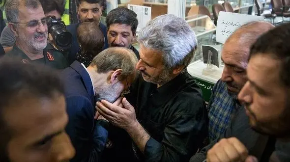 بوسه علی لاریجانی بر دستان پدر شهید حججی
