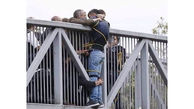عکس لحظه خودکشی مرد جوان  از روی پل / مردم او را به نرده بستند ! 