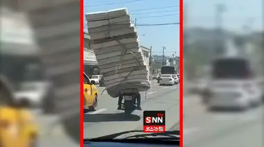 فیلم / موتورسیکلت سوار با بار عظیم تشک‌ها