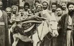 عکس سفر زمان /  مرد بار فروش با الاغ اش در حال عبور از خیابان فردوسی تهران و جلوی صرافی کوروش؛ سال 50