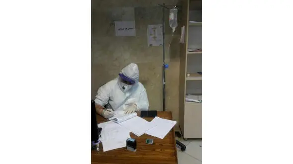 پزشکی که سرم به دست در حال کمک به مبتلایان به کرونا است  +عکس 