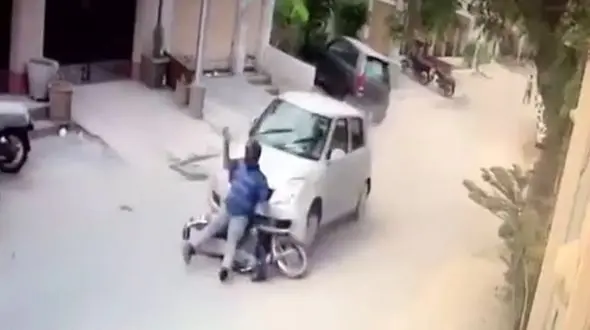 گرفتاری عجیب موتور سوار از زیر چرخ‌های ماشین + فیلم