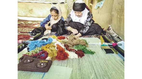 روستایی با تارهای رنگین کمانی گلیم بافی