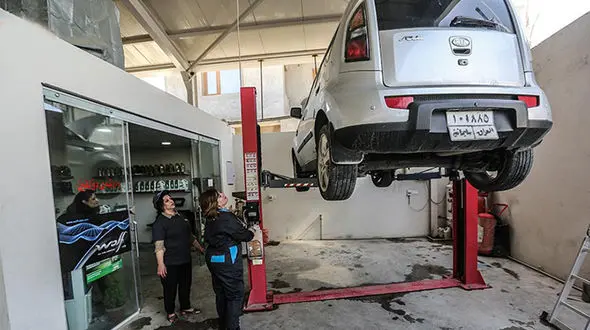  زن عراقی پس از شکست در انتخابات در تعویض روغنی کارگری می کند+ تصاویر