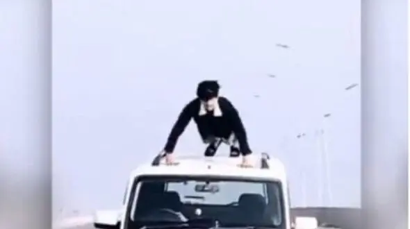حرکت نمایشی خطرناک راننده روی سقف خودرو + فیلم
