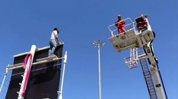 کارگر نصاب تابلوهای تبلیغاتی قبل از سقوط نجات یافت +عکس