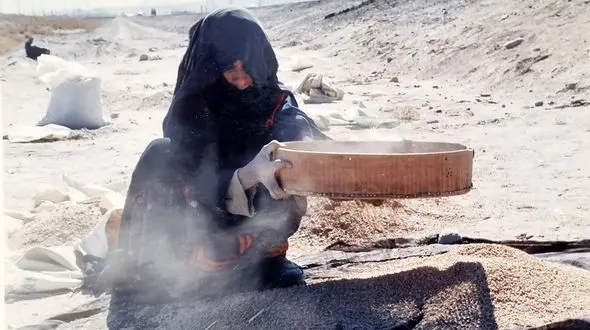 الک کردن خاک توسط زن ساکن بلوچستان، برای پیدا کردن دانه ای گندم! + فیلم