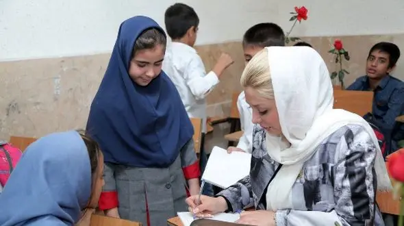 به صدا درآوردن زنگ آغاز سال تحصیلی جدید به دست نیوشا ضیغمی؛ ابتکار خانم بازیگر در پوشیدن مانتویی با تصویر کودکان کار و اهدای گل به دانش آموزان+عکس