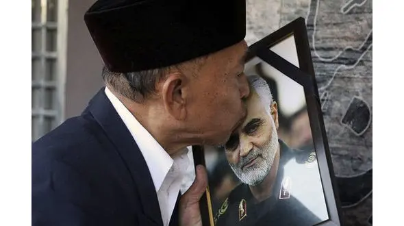 بوسه پیرمرد مالزیایی بر قاب عکس سردار شهید قاسم سلیمانی + عکس ها