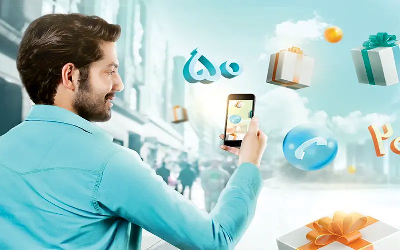 A man holding an iphone in his hand surrounded by gifts flying from sky