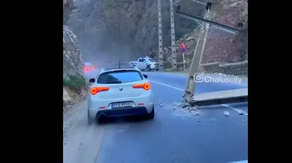 ببینید / افتادن تیر چراغ برق وسط جاده چالوس