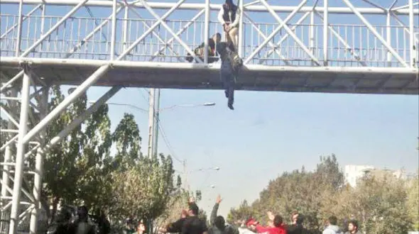 عکس لحظه آویزان شدن زن جوان از پل آهنی / او می خواست شوهرش را بترساند!