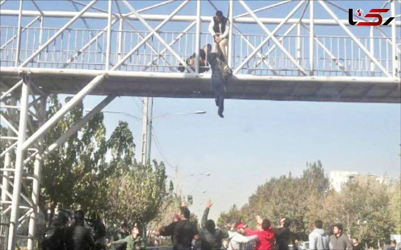 عکس لحظه آویزان شدن زن جوان از پل آهنی / او می خواست شوهرش را بترساند!