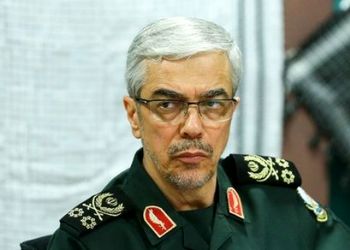 عکس سفر به تاریخ / «سپهبد باقری» در یک منطقۀ جنگی در سوریه در حال بررسی نقشۀ نظامی