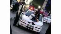 عکس دختر بدحجاب که روی ماشین پلیس نشست / او در آذربایجان غربی بازداشت شد