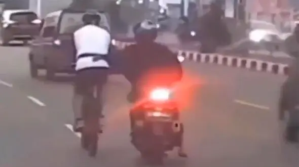 ببینید / لحظه عجیب سرقت از یک دوچرخه‌سوار در حال حرکت توسط سرنشین موتور!