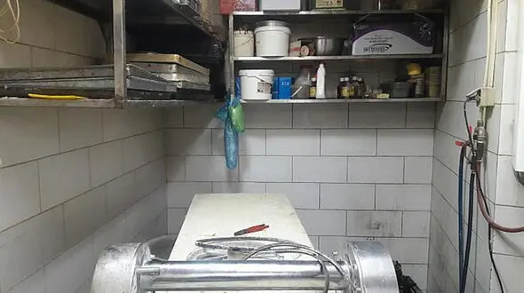 دست کارگر شیرینی پزی زیر دستگاه خمیر کوب 