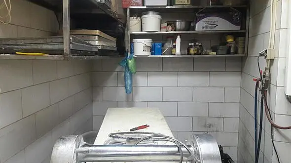 دست کارگر شیرینی پزی زیر دستگاه خمیر کوب 