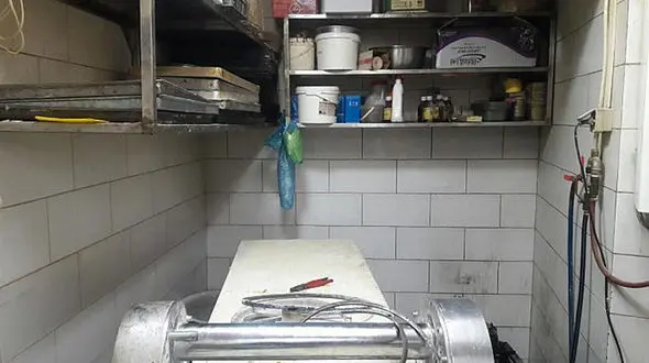 دست کارگر شیرینی پزی زیر دستگاه خمیر کوب 