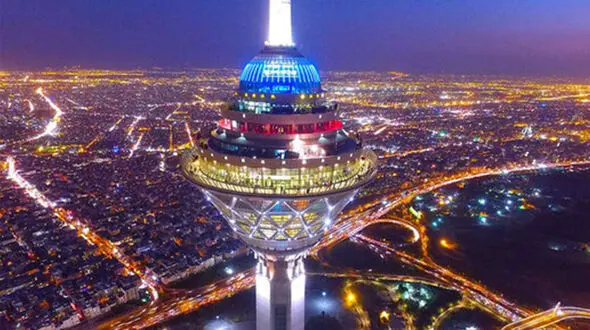 بینید / پیدا شدن ماه از پس برج میلاد تهران در هوای غبارآلود تهران + فیلم 