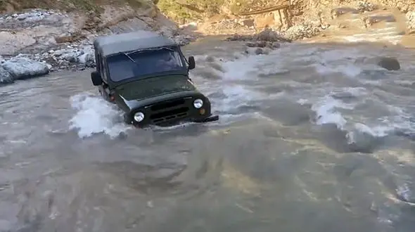 دردسر خاموش شدن خودروی جیپ وسط رودخانه‌ خروشان + فیلم و عکس