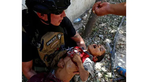 لحظه تکان دهنده از کودکی نجات یافته از دست داعش + عکس