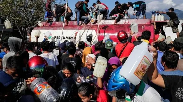 
مردم سونامی‌زده در اندونزی به فروشگاه‌ها هجوم بردند/ دفن گروهی قربانیان+ تصاویر
