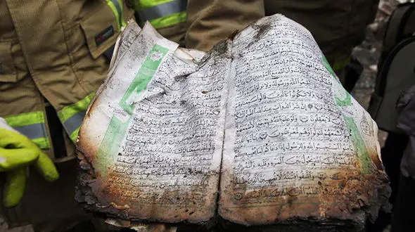 بوسه بر قرآنی که در حرارت بالای پلاسکو سالم مانده است+ تصاویر 