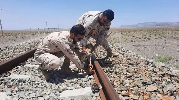 عکس دیدنی از نجات بچه آهو توسط مرزداران هنگ تایباد / روی ریل راه آهن گرفتار شده بود